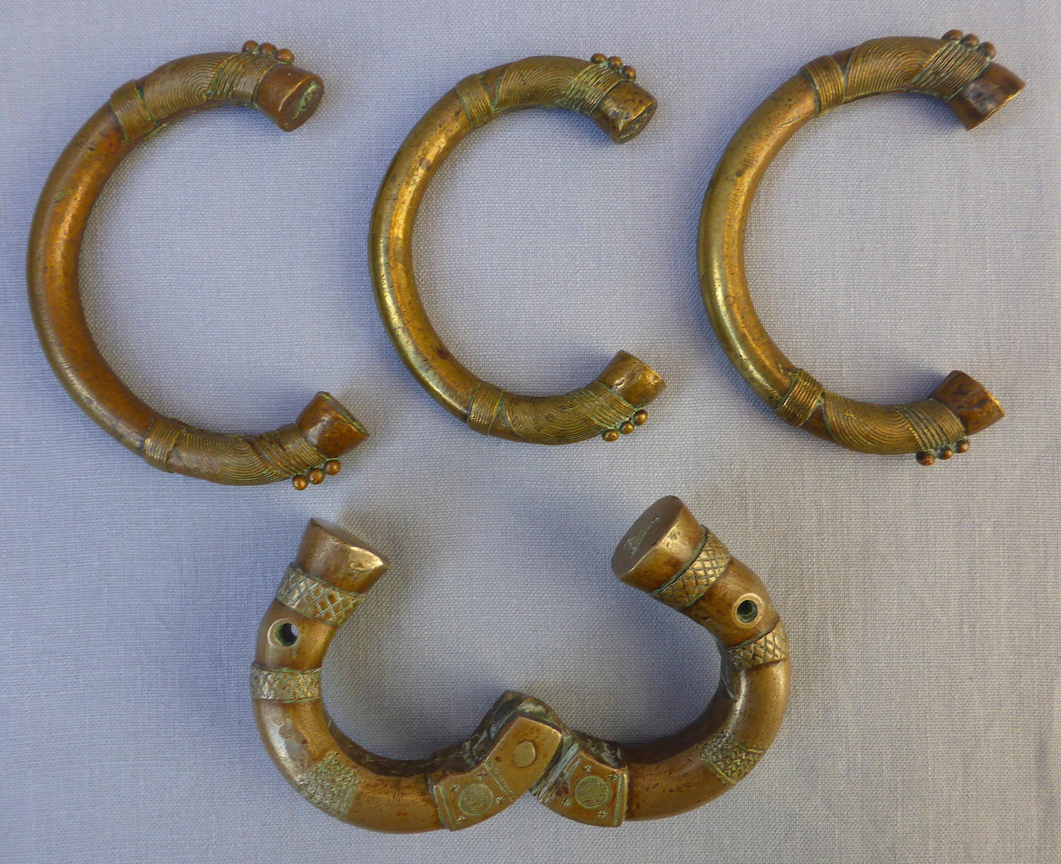 Four 19th century bronze manilla slave currency bracelets